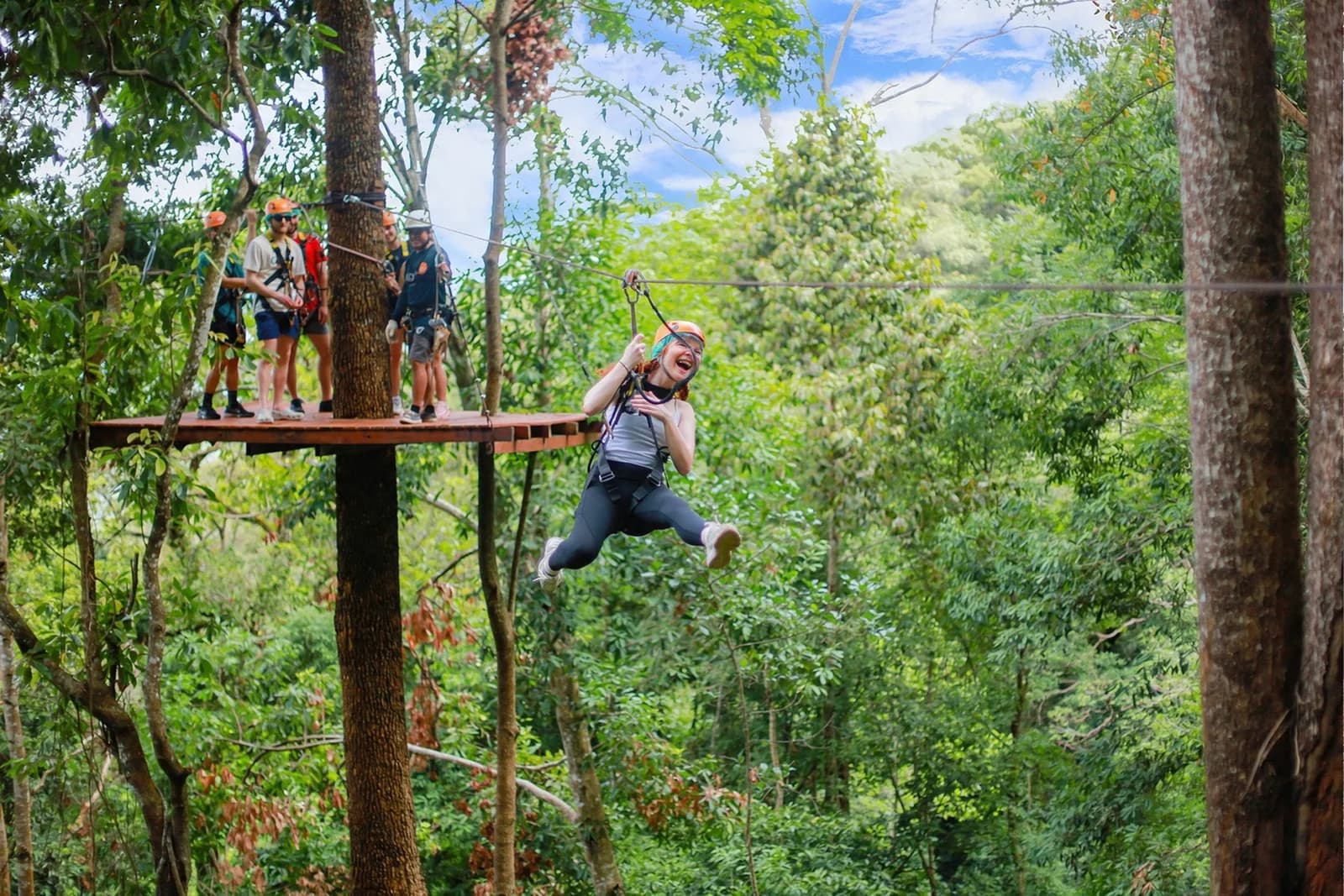 A participant in leggings and closed-toe shoes leaving a forest platform