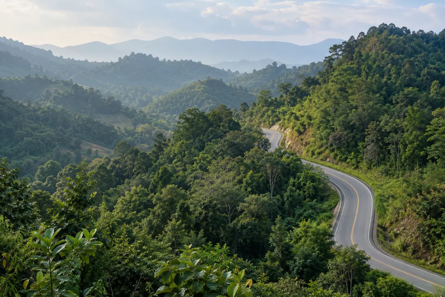 A winding road passing through green wooded hills